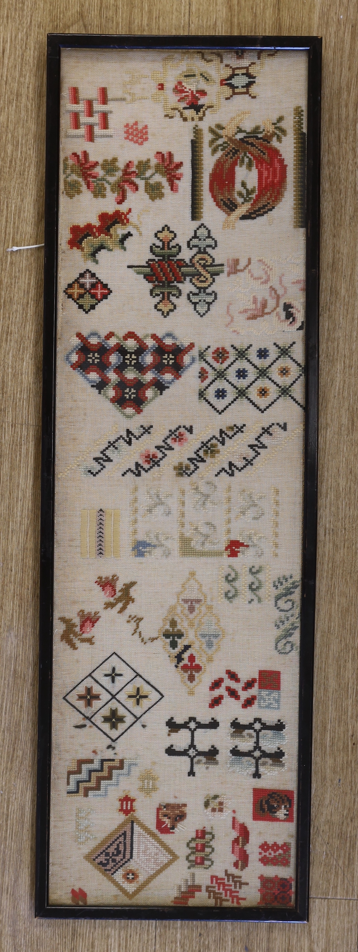 A Regency silk and wool embroidery of a seated boy by a tree and a Victorian spot motif wool-worked sampler, Regency embroidery 29.5cm x 33cm wide